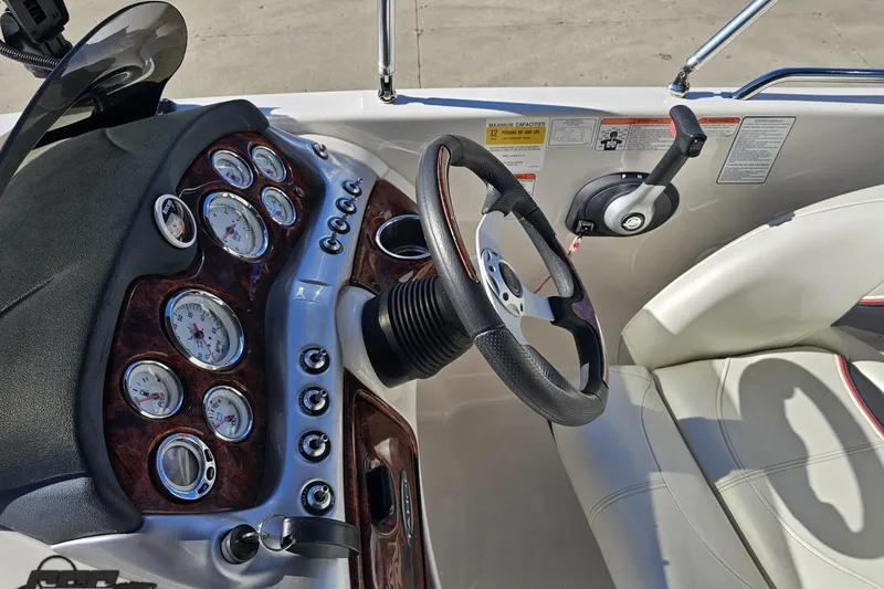 Slide: The Image of 2015 Tahoe 215 Xi boat dashboard with gauges, steering wheel, and control lever. - 62
