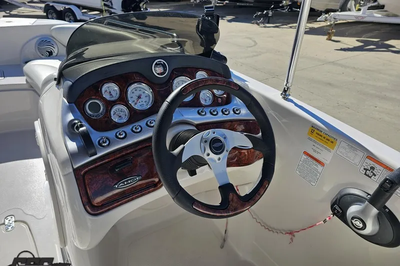 Slide: The Image of 2015 Tahoe 215 Xi boat dashboard with steering wheel and gauges. - 65