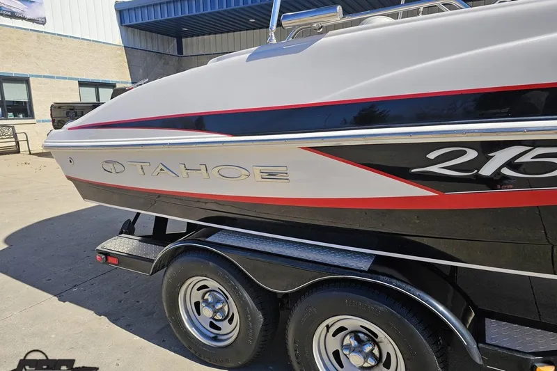 Slide: The Image of 2015 Tahoe 215 Xi boat on trailer, featuring sleek design and bold graphics. - 7
