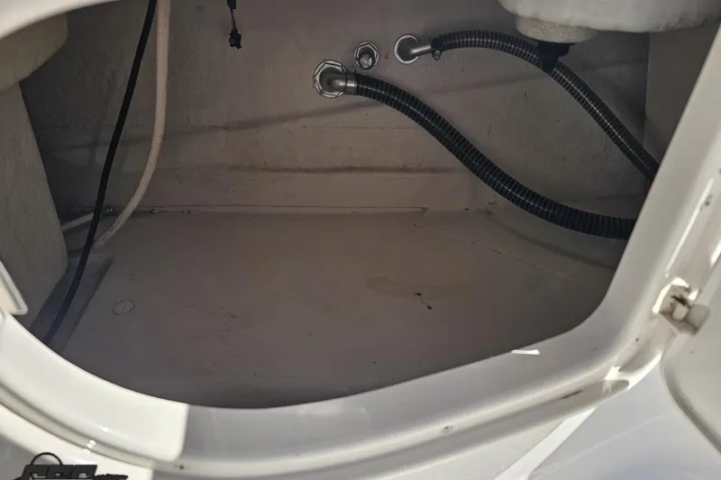 Slide: The Image of Storage compartment of a 2015 Tahoe 215 Xi boat, featuring hoses and fittings. - 79