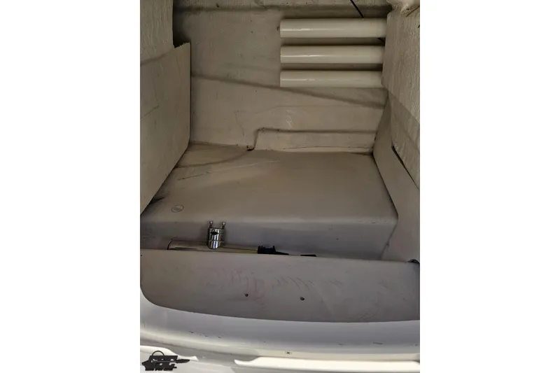 Slide: The Image of Interior storage compartment of a 2015 Tahoe 215 Xi boat, featuring a clean, white finish. - 84