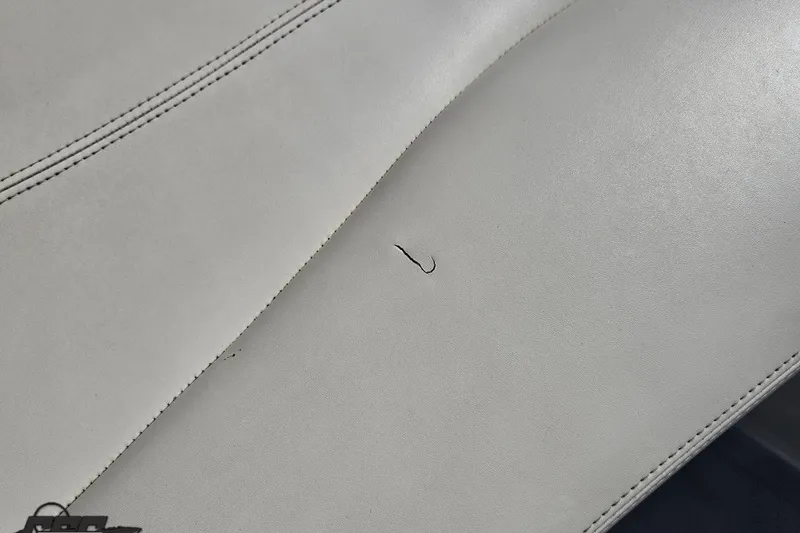 Slide: The Image of White leather seat with a small tear, 2015 Tahoe 215 Xi boat interior. - 91