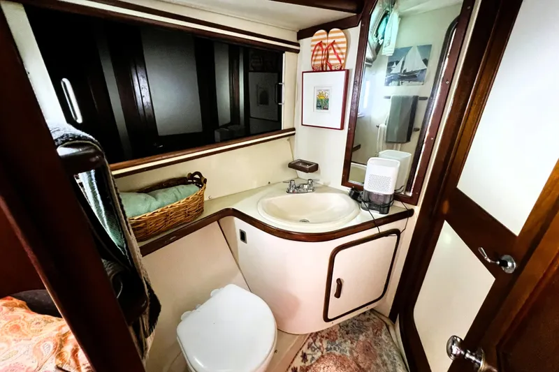 Slide: The Image of Cozy 1985 Gulfstar Hirsch Center Cockpit interior with blue sofa and decorative pillows. - 11