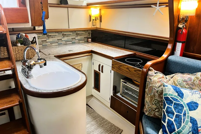 Slide: The Image of Cozy 1985 Gulfstar Hirsch Center Cockpit bedroom with nautical-themed quilt and wooden cabinetry. - 13