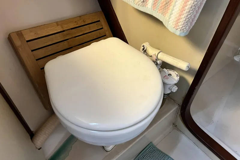 Slide: The Image of 1985 Gulfstar Hirsch Center Cockpit sailboat docked, featuring a blue canopy and steering wheel. - 3