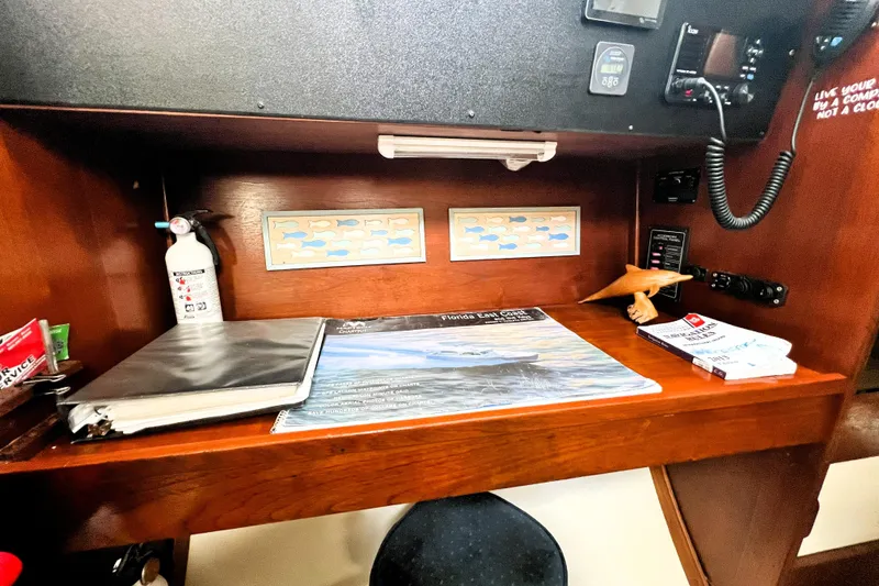 Slide: The Image of Cozy 1985 Gulfstar Hirsch Center Cockpit interior with blue sofa, nautical decor, and wall-mounted TV. - 9