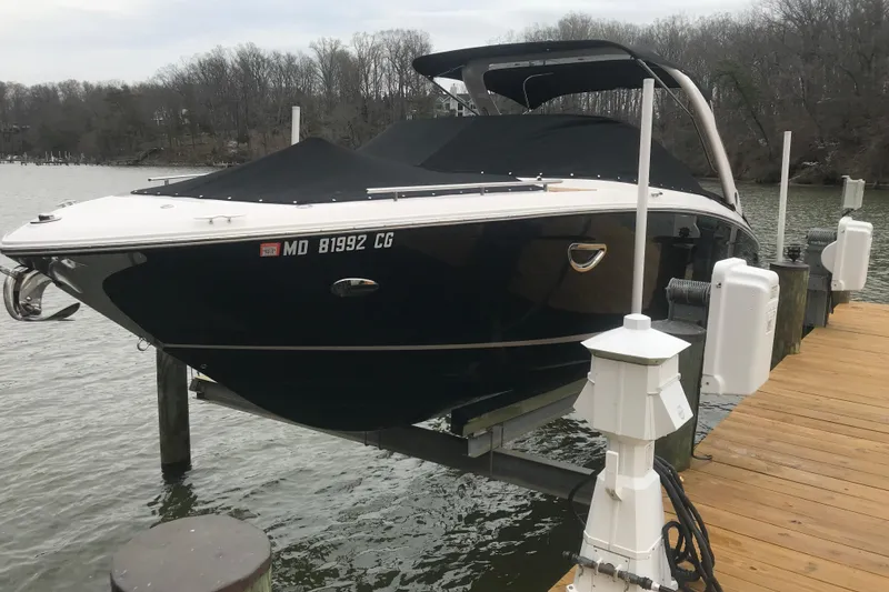 The Image of 2015 Regal 2800 Bowrider boat docked on a lift by a wooden pier. - 0