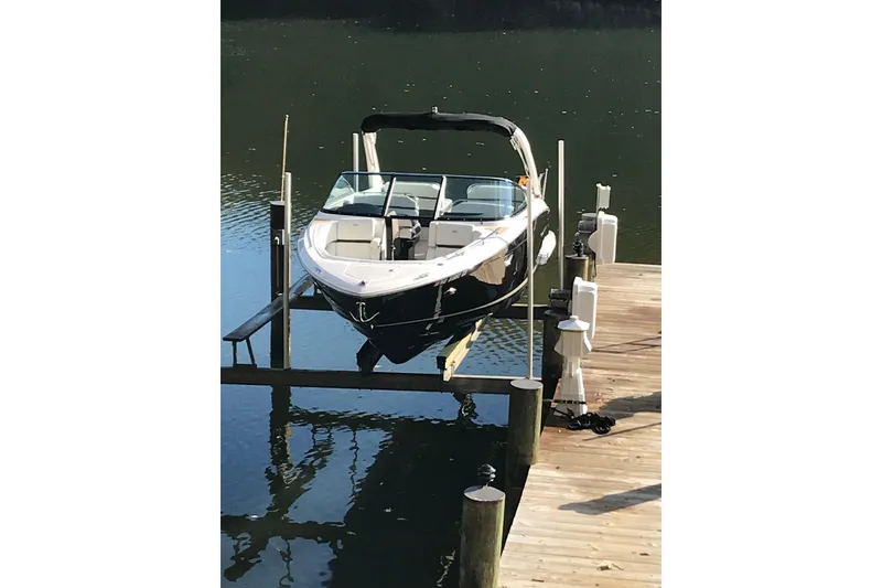 Slide: The Image of 2015 Regal 2800 Bowrider boat docked on a wooden pier. - 2