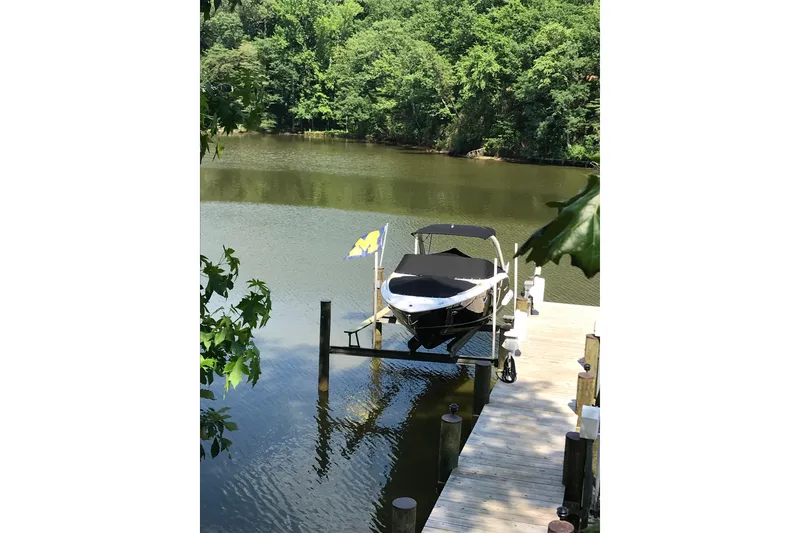 Slide: The Image of 2015 Regal 2800 Bowrider docked on a serene lake with lush greenery. - 3