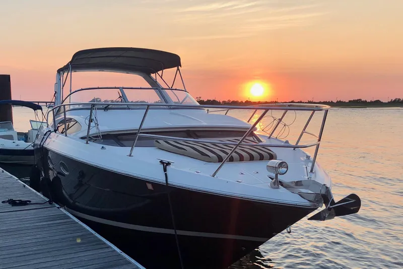 The Image of 2012 Regal 35 Express Cruiser docked at sunset, serene waterfront view. - 0