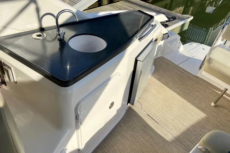 Slide: The Image of 2012 Regal 35 Express Cruiser interior with sink, countertop, and seating area. - 13