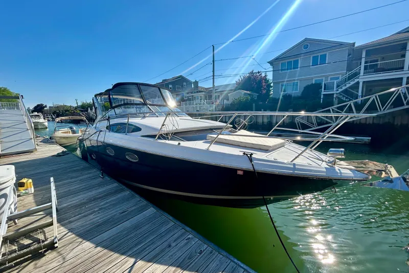 Slide: The Image of 2012 Regal 35 Express Cruiser docked at a marina under clear blue skies. - 2