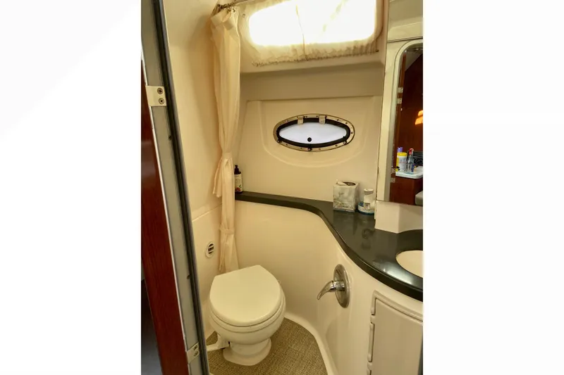 Slide: The Image of Bathroom interior of 2012 Regal 35 Express Cruiser with toilet, sink, and porthole window. - 22
