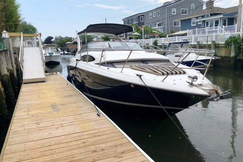 Slide: The Image of 2012 Regal 35 Express Cruiser docked beside a wooden pier in a residential canal. - 3