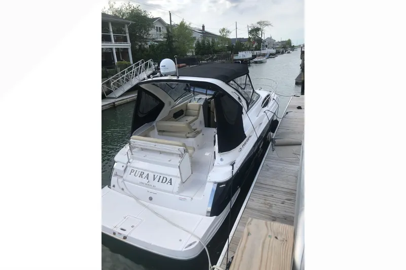 Slide: The Image of 2012 Regal 35 Express Cruiser docked, featuring sleek design and black canopy. - 5