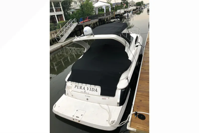 Slide: The Image of 2012 Regal 35 Express Cruiser docked, covered, with "Pura Vida" on the stern. - 7