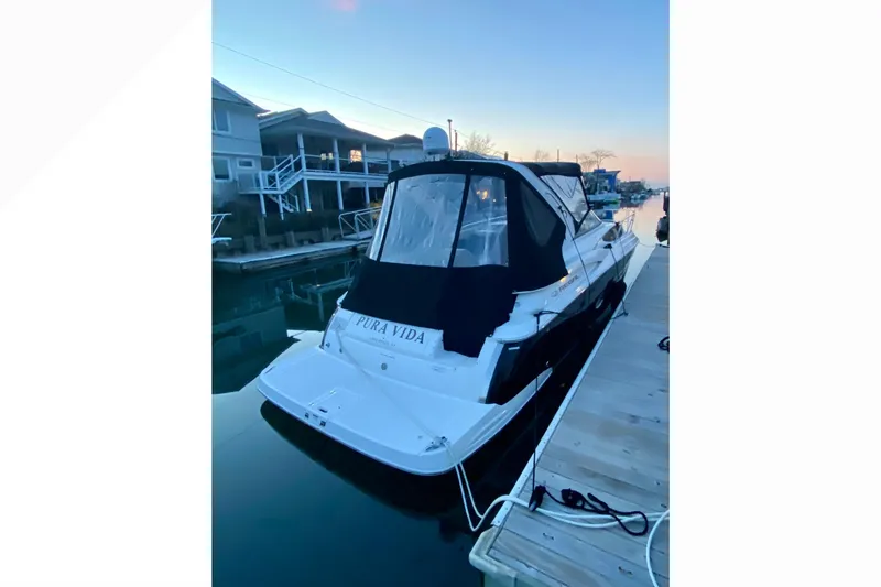 Slide: The Image of 2012 Regal 35 Express Cruiser docked at sunset, featuring sleek design and covered cockpit. - 8