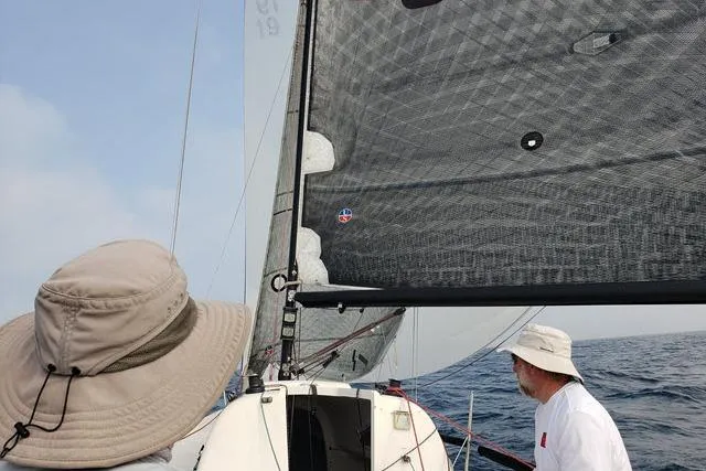 Slide: The Image of Sailors navigating a 2006 Flying Tiger 10M yacht on open water. - 6