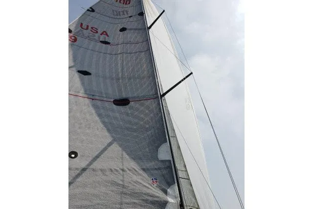 Slide: The Image of Sail of a 2006 Flying Tiger 10M yacht against a cloudy sky. - 9