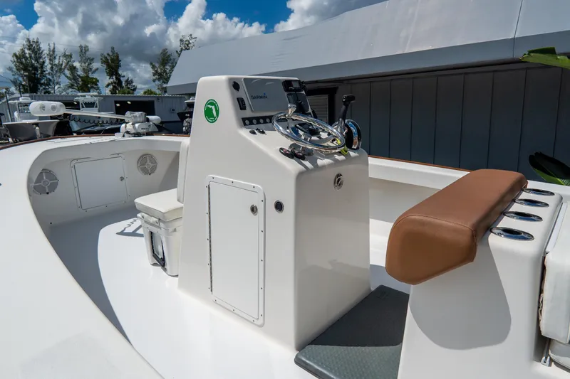 Slide: The Image of 2022 Croswait 21 boat console with steering wheel and seating under a cloudy sky. - 10