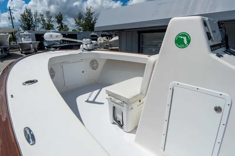 Slide: The Image of 2022 Croswait 21 boat interior with seating, storage, and control panel under a blue sky. - 12