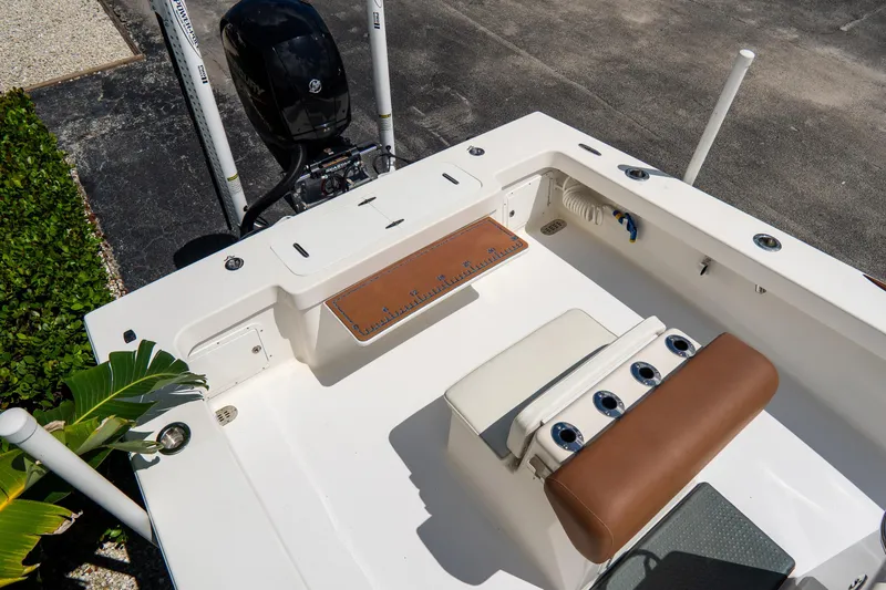 Slide: The Image of Croswait 21 boat interior, 2022 model, featuring seating and motor, docked outdoors. - 25