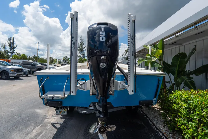 Slide: The Image of Blue Croswait 21 boat with a 150 HP outboard motor, parked outdoors, 2022 model. - 4