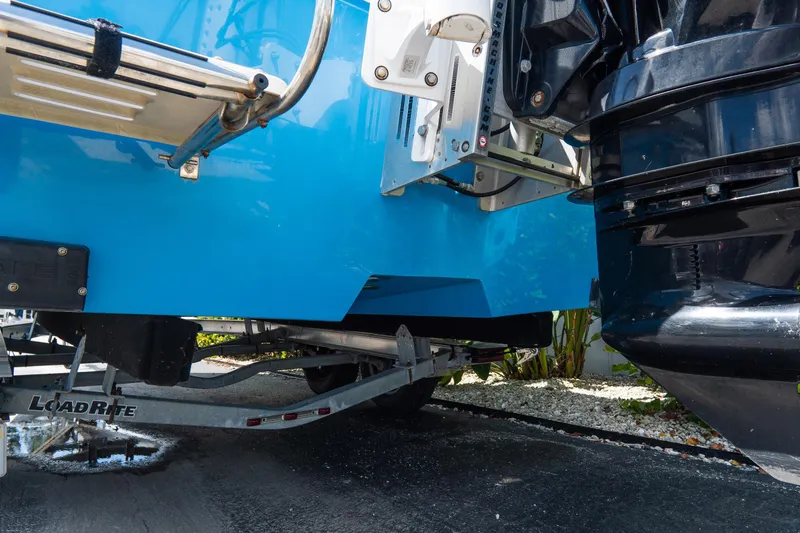 Slide: The Image of Blue Croswait 21 boat on LoadRite trailer, showcasing outboard motor and hull details. - 6