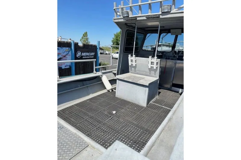 Slide: The Image of 1998 Fishing 22 boat interior with seating and rod holders, Mercury dealer sign visible. - 2