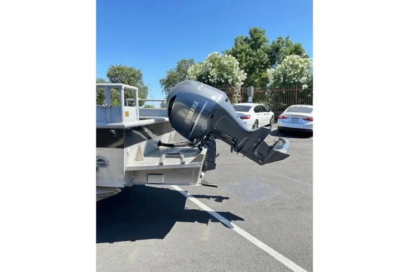 Slide: The Image of Boat with Yamaha outboard motor in parking lot, surrounded by trees and cars. - 4