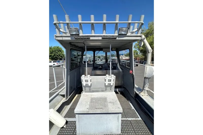 Slide: The Image of 1998 Fishing 22 boat interior with rod holders and seating, parked outdoors. - 5