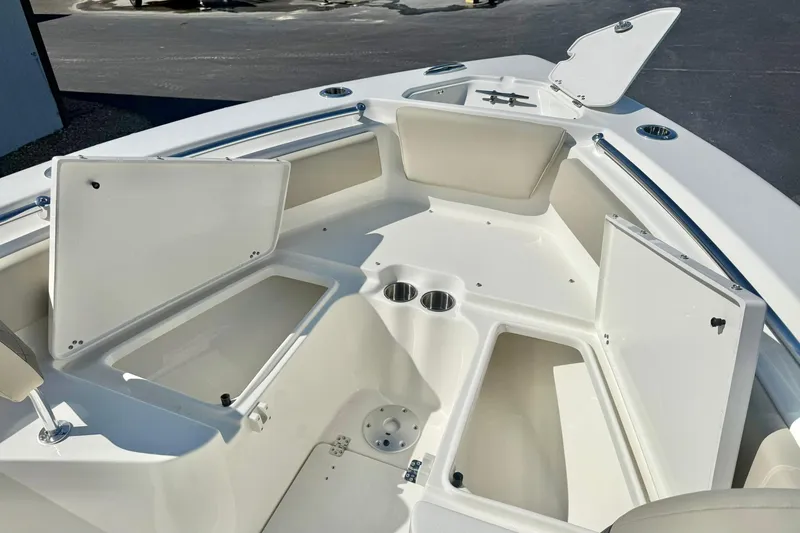 Slide: The Image of 2026 Key West 239 FS boat interior with open storage compartments and cup holders. - 16