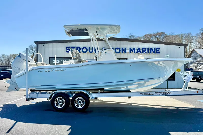 Slide: The Image of 2026 Key West 239 FS boat on trailer at dealership, sunny day. - 7