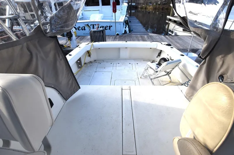 Slide: The Image of 1987 Luhrs Alura 35 boat deck with seating, docked near other vessels. - 11