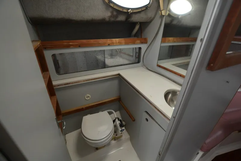 Slide: The Image of 1987 Luhrs Alura 35 boat bathroom with toilet, sink, and wooden accents. - 20