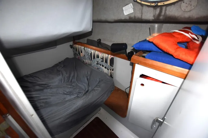 Slide: The Image of 1987 Luhrs Alura 35 cabin interior with bed, life jackets, and storage. - 21