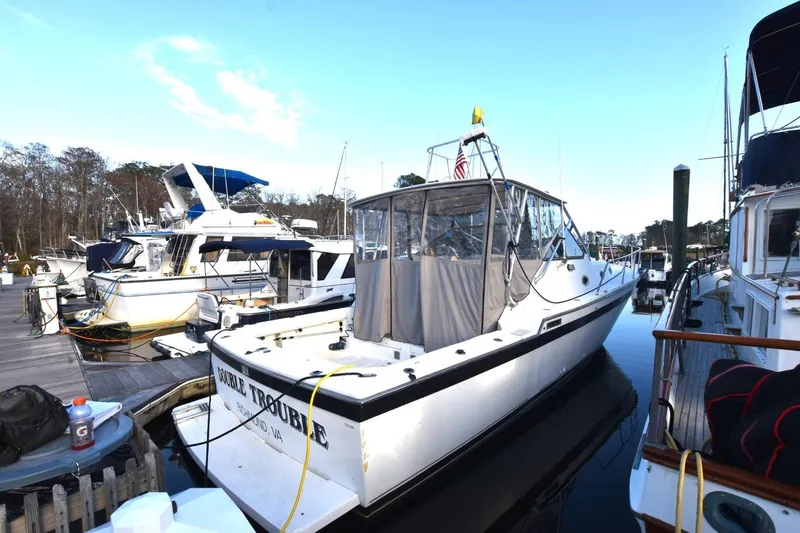 Slide: The Image of 1987 Luhrs Alura 35 boat docked at marina, surrounded by other vessels. - 3