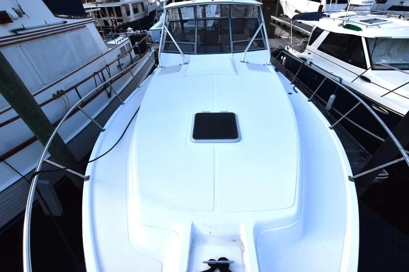 Slide: The Image of 1987 Luhrs Alura 35 boat docked, showcasing spacious deck and sleek design. - 6