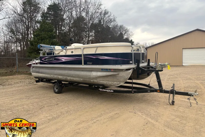 The Image of 2012 Sylvan 820 Mirage Cruise pontoon boat on trailer, parked outdoors. - 1