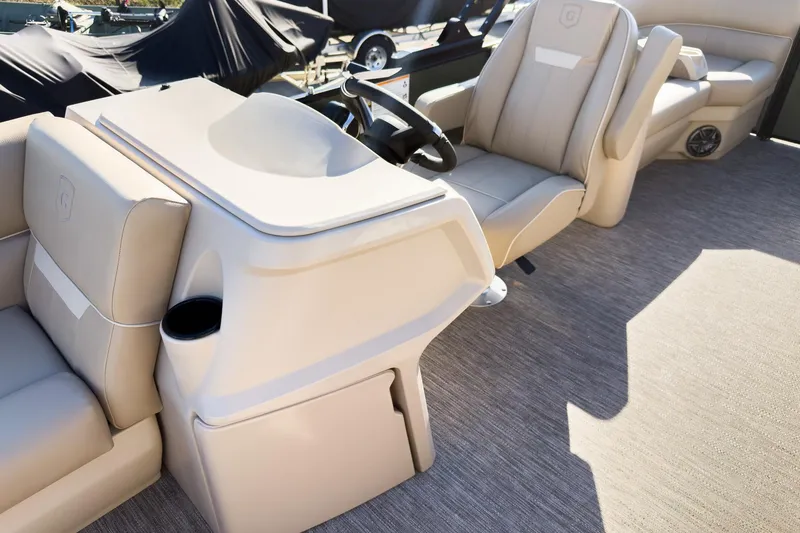Slide: The Image of 2026 Godfrey Sweetwater Xperience 22' Tritoon interior with beige seating and steering console. - 15