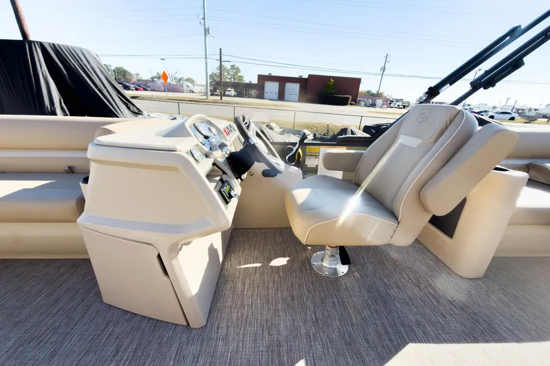 Slide: The Image of Interior of 2026 Godfrey Sweetwater Xperience 22' Tritoon, featuring helm and captain's chair. - 16