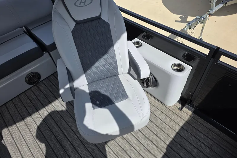 Slide: The Image of Captain's chair on 2021 Harris Solstice 230 SL boat, featuring cup holders and speaker. - 14