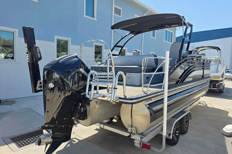 Slide: The Image of 2021 Harris Solstice 230 SL pontoon boat with sleek design, parked on a trailer. - 3