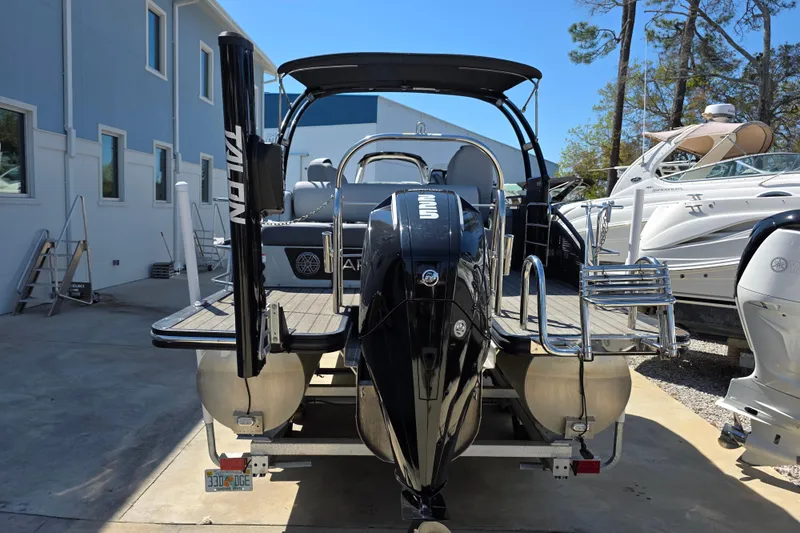 Slide: The Image of 2021 Harris Solstice 230 SL pontoon boat with outboard motor, docked near other boats. - 4