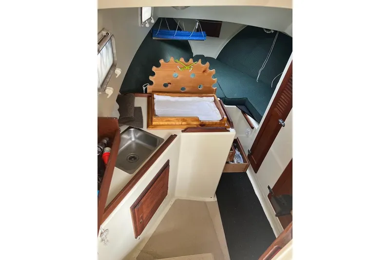 Slide: The Image of 1998 General Marine Custom Downeast boat interior with sink, storage, and seating area. - 23