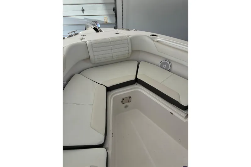 Slide: The Image of Interior seating of 2020 Edgewater 262CC boat, featuring cushioned seats and storage compartment. - 10