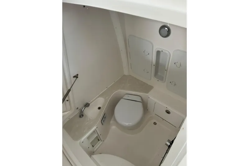 Slide: The Image of 2020 Edgewater 262CC boat interior with compact marine toilet and sink. - 13