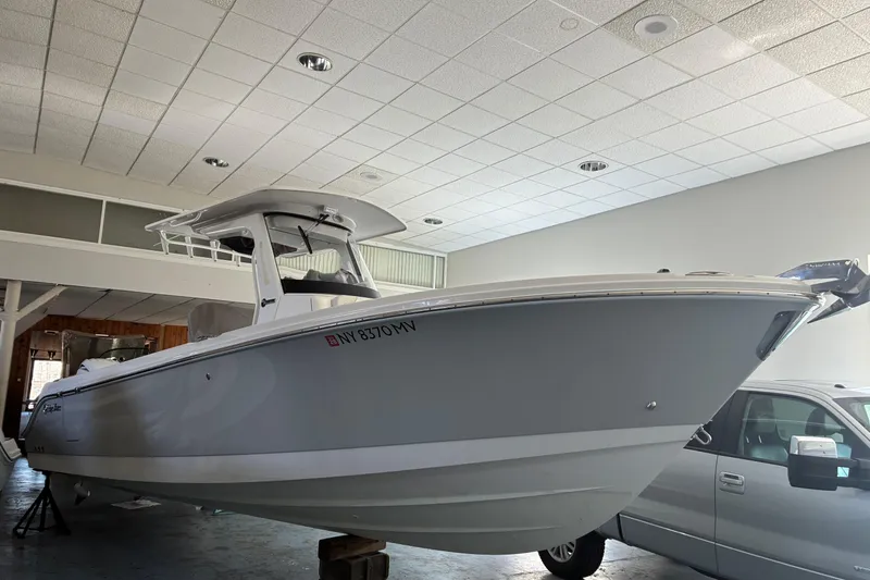 Slide: The Image of 2020 Edgewater 262CC boat displayed indoors, showcasing sleek design and modern features. - 8