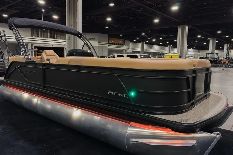 The Image of 2026 Godfrey Sweetwater 22' Split Bench Tritoon on display indoors, featuring sleek design and comfortable seating. - 0