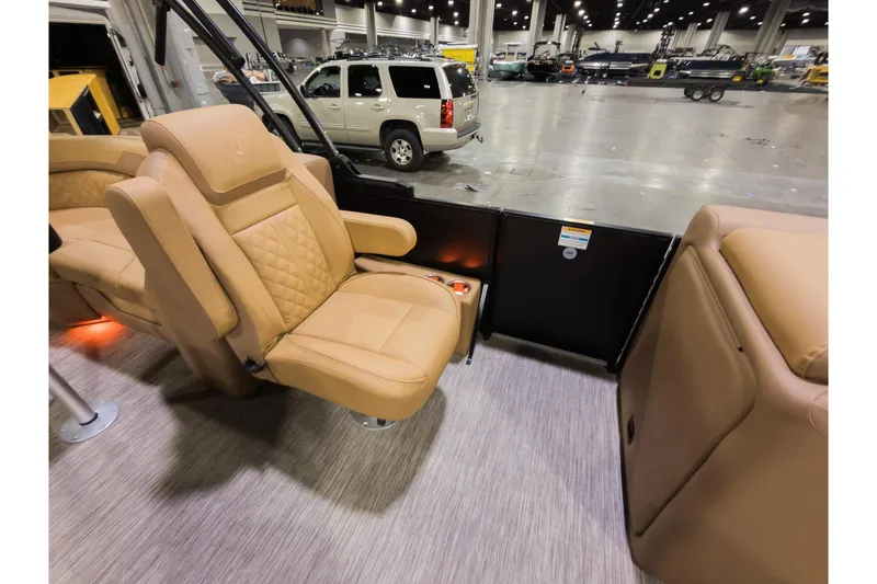 Slide: The Image of 2026 Godfrey Sweetwater 22' Tritoon interior with luxurious tan seating in a showroom. - 13